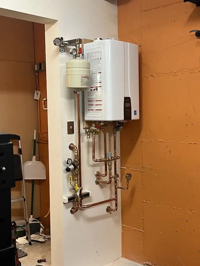 Plumbing technician inspecting water heater connections in Alamo